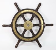 A teak and brass helm inscribed 'Betty': the brass boss with black enamelled text radiating turned