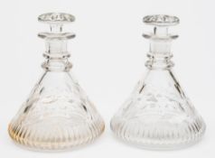 A pair of cut glass ship's decanters:, of typical form with mushroom stoppers ,