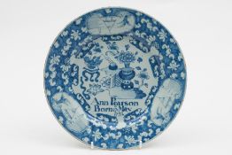 An English dated delftware plate: painted in blue with a Chinese vase of flowers and a flower table