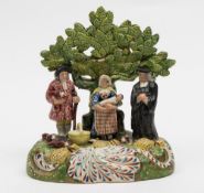 A pearl glazed tithe pig group of Walton type: modelled in the typical fashion with three figures