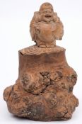 A Japanese carved tea tree figure possibly of Ebisu: holding a large carp under his arm,