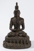 A South East Asian bronze figure of Buddha: seated in lotus position on a lotus flower base, 31cm.