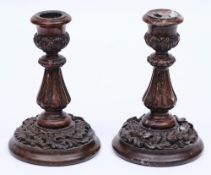 A pair of early 19th Century carved walnut candlesticks: decorated with oak leaves and acorns,