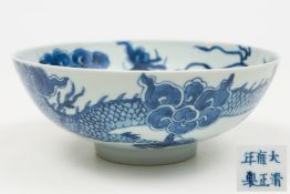 A Chinese porcelain bowl: of circular form the interior painted in blue with a single dragon