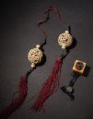 A pair of Chinese ivory small puzzle balls and a similar pendant in the form of a pierced box: the