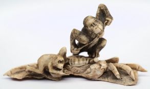 A Japanese carved ivory okimono of two monkeys climbing on a crab: the taller monkey with a rope in