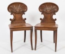 By Gillows, Lancaster - A pair of Regency carved oak hall chairs:,