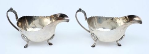 A pair of Edward VII silver sauce boats, maker GH, Sheffield, 1903: with wavy edge borders,