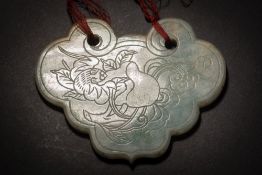 A Chinese jadeite plaque: of ruyi-head  form, one side engraved with a bat, fruit and lingzhi,