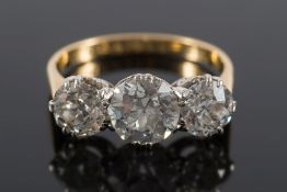 A diamond mounted three-stone ring: with central round old brilliant-cut stone approximately 7.
