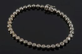 A diamond mounted line bracelet: of circular links each inset with a brilliant-cut diamond,