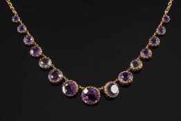 An amethyst mounted fringe necklace: with graduated, circular amethysts in cut-down collet settings.
