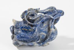 A carved lapis lazuli group: of three mythical birds with flower stems in their beaks, 15cm. long.