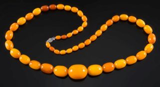 A graduated amber bead single string necklace: with 49 oblong beads, the largest bead 35.