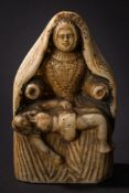A continental carved alabaster group of the Pieta: Mary seated in 16th century costume with shawl