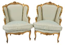 A pair of French carved giltwood bergere armchairs in the Louis XV taste:,