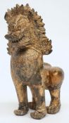 A Far Eastern  gilded bronze temple lion: of traditional design, standing on all fours,