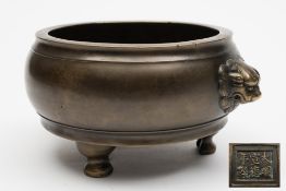 A Chinese bronze tripod censer: of compressed globular form with Buddhist lion-head handles between