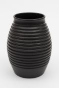 A Keith Murray for Wedgwood annular vase: the black basalt body of ribbed oviform,