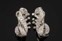 A pair of diamond mounted scroll cluster clip earrings: of openwork design with circular and