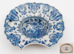 A Dutch delft barber's bowl: of fluted 'helmet' form, the ribbed border with small well,