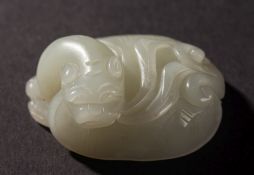 A Chinese celadon jade carving of a mythical turtle: its head leaning to one side, 5.5cm. long.