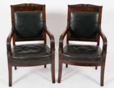 A pair of early 19th Century French Restauration carved mahogany fauteuils:,