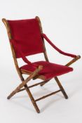 A 19th Century beechwood simulated bamboo folding campaign chair:, with foliate painted decoration,
