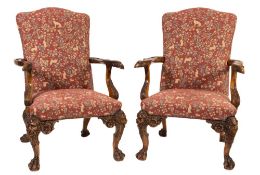 A pair of carved mahogany library armchairs in the 18th Century Irish taste:,
