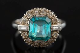 A blue zircon and diamond cluster ring: with central 'emerald-cut' blue zircon within a border of