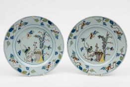 A pair of English polychrome delft plates: each painted with a long tailed bird amongst flowering