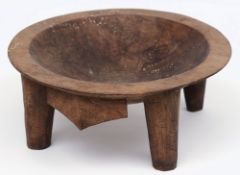 A Fijian hardwood carved bowl: of circular form raised on four peg feet, 31cm.