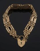 A 9ct gold four bar, gate-link bracelet: with padlock clasp and safety chain,