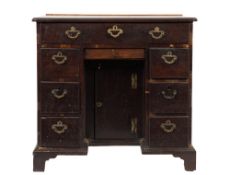 A mid 18th Century mahogany kneehole desk:, the top with a moulded edge and re-entrant corners,