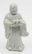A Chinese blanc de chine  figure: modelled as a bearded and bald headed monk in flowing robes