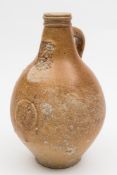 A salt glazed stoneware Bellarmine or Bartmann Krug: of typical bellied form with grooved strap