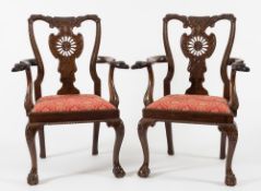 A pair of carved mahogany open armchairs:, in the Chippendale taste,