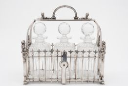 A late Victorian plated three bottle tantalus: the cage of garden fence design,