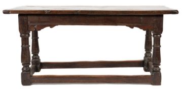 An antique oak dining table: with a rectangular overhanging top and apron with fret cut spandrels,