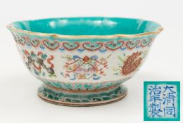 A Chinese porcelain bowl: of octofoil form enamelled in the famille rose palette with the eight
