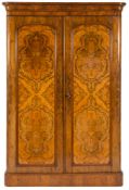 A Victorian figured walnut wardrobe:, with a moulded cornice, fitted with sliding trays,