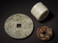 A Chinese jade archer's ring and two discs: the archer's ring carved with a four-character