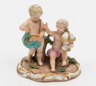 A Meissen porcelain allegorical group of two cherubs emblematic of Geography: one holding a globe,