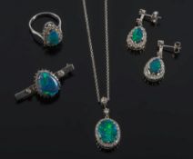 A suite of black opal and diamond jewellery: including an oval cluster pendant with central oval