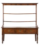 An early 19th Century oak dresser:, the shelved super-structure with a moulded cornice,