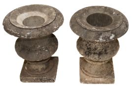 A pair of marble urns in the neo-classical taste: of reeded form, raised on a square plinth base,