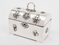 A white metal domed jewellery casket: the domed hinged lid with spiral loop handle,