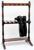 An early 20th century mahogany boot stand together with a pair of black leather riding boots:.