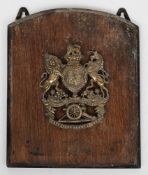 A Royal Artillery brass military helmet plate: mounted on a polished board.