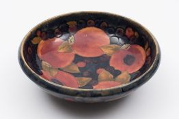 A Moorcroft pottery bowl: of circular form tube lined in the Pomegranate pattern in red, orange,